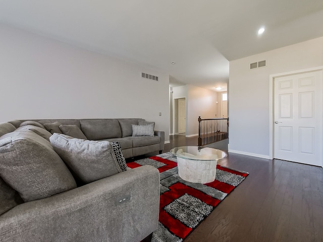 living room with visible vents, baseboards, and dark wood-type flooring