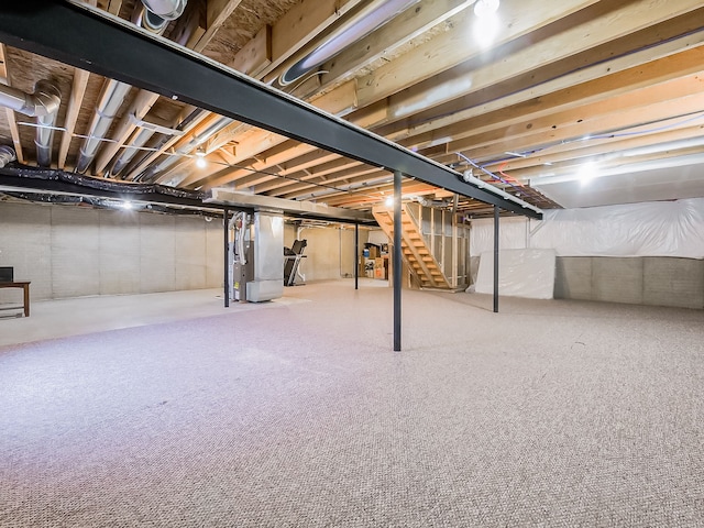 unfinished basement with stairway and heating unit