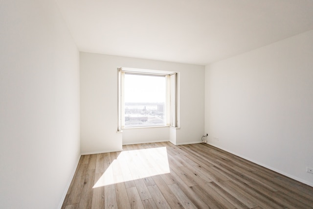 spare room with visible vents, baseboards, and wood finished floors