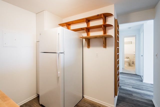 kitchen with dark wood finished floors, electric panel, baseboards, and freestanding refrigerator