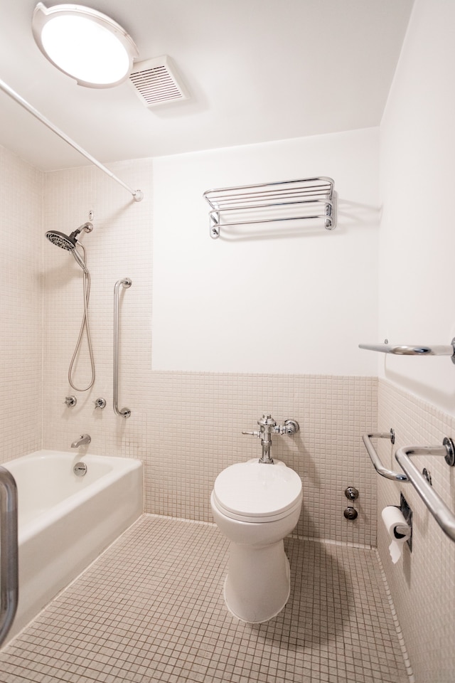 full bath featuring tile patterned flooring, visible vents, toilet, and tile walls