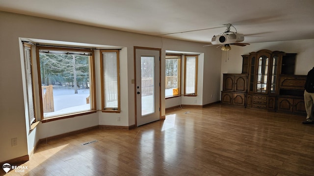 entryway with visible vents, baseboards, a ceiling fan, and wood finished floors