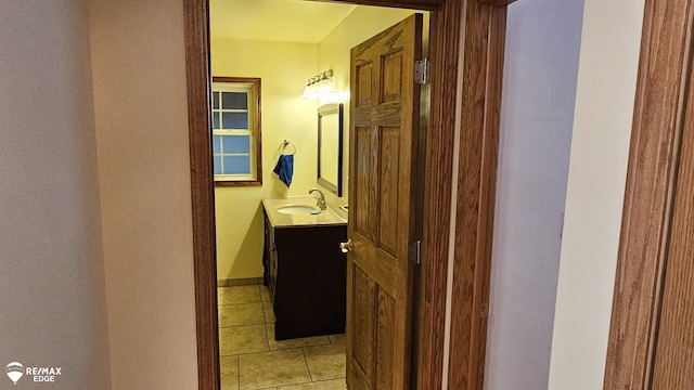 hallway featuring a sink and light tile patterned flooring