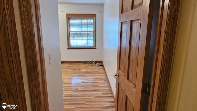 corridor with wood finished floors and baseboards