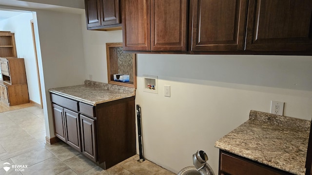 laundry room with cabinet space, washer hookup, light tile patterned floors, and baseboards