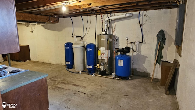 unfinished below grade area with gas water heater and a water pressure tank