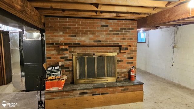 basement view of unfinished concrete flooring, a brick fireplace, and a fire extinguisher