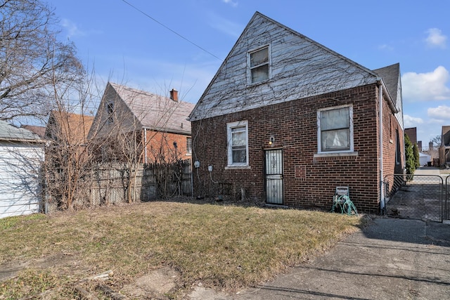 exterior space featuring a yard, fence, and brick siding