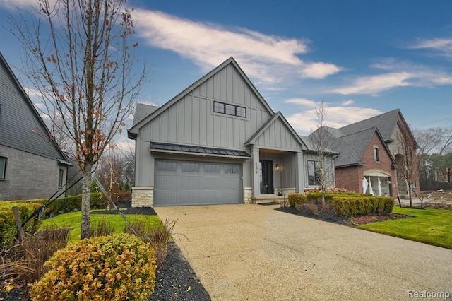 modern inspired farmhouse featuring board and batten siding, metal roof, stone siding, driveway, and a standing seam roof