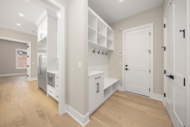 mudroom with recessed lighting, baseboards, and light wood finished floors