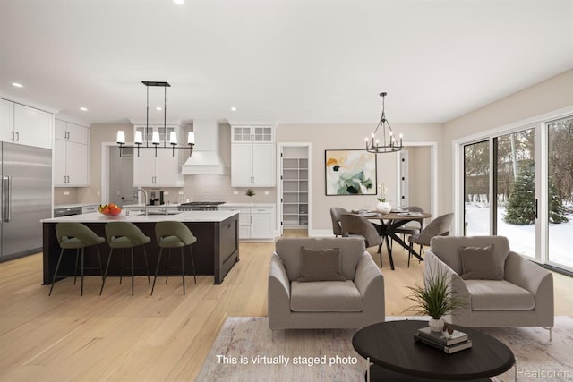 living room with recessed lighting, a chandelier, and light wood finished floors