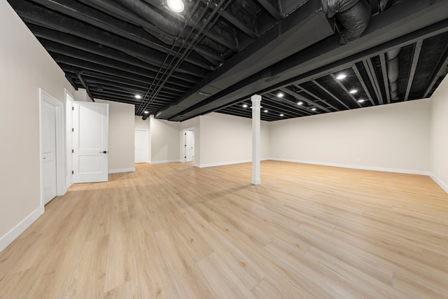 finished basement featuring baseboards and wood finished floors