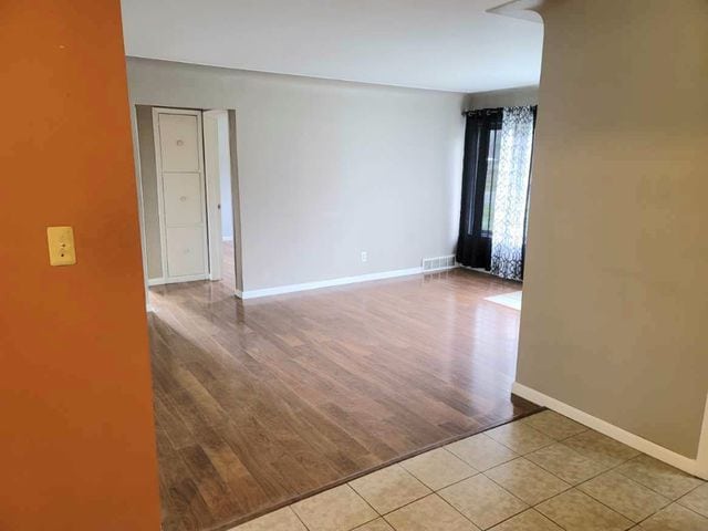 spare room featuring light tile patterned floors, baseboards, and visible vents