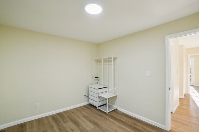 3736 Iroquois St, Detroit, MI 48214 - unfurnished bedroom featuring wood finished floors and baseboards