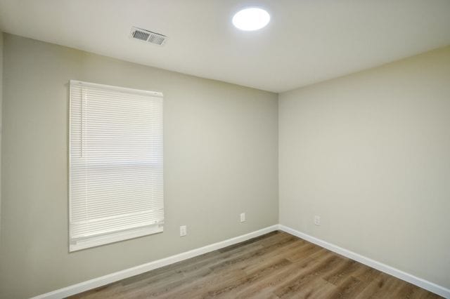3736 Iroquois St, Detroit, MI 48214 - spare room with wood finished floors, visible vents, and baseboards