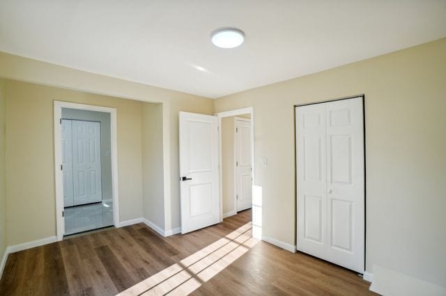 3736 Iroquois St, Detroit, MI 48214 - unfurnished bedroom with a closet, baseboards, and wood finished floors