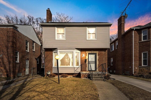 colonial home featuring brick siding and a chimney