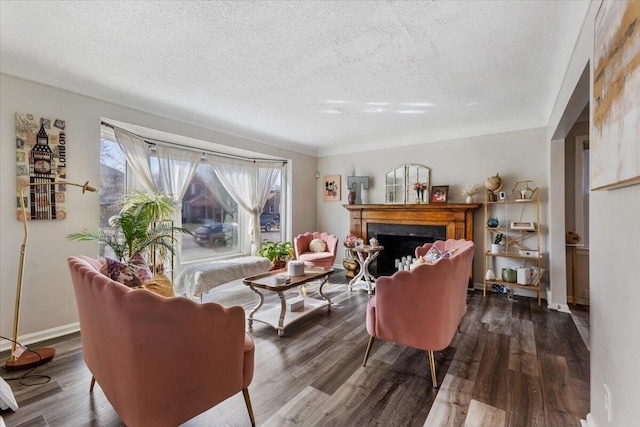 living area with a textured ceiling, wood finished floors, and a fireplace