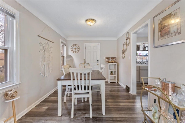 dining area with baseboards, dark wood-type flooring, and a textured ceiling