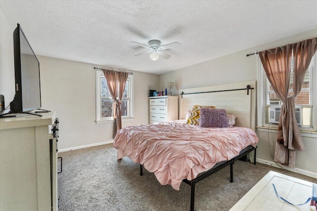 carpeted bedroom with a textured ceiling, baseboards, and a ceiling fan