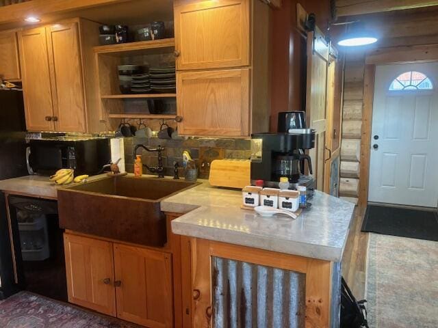 kitchen featuring open shelves, decorative backsplash, light countertops, and a sink