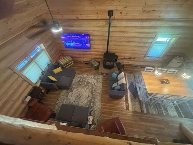 living room featuring log walls, wood finished floors, and a wood stove