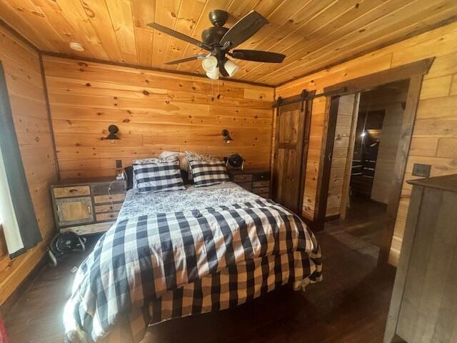 bedroom featuring wooden walls, wooden ceiling, and a barn door