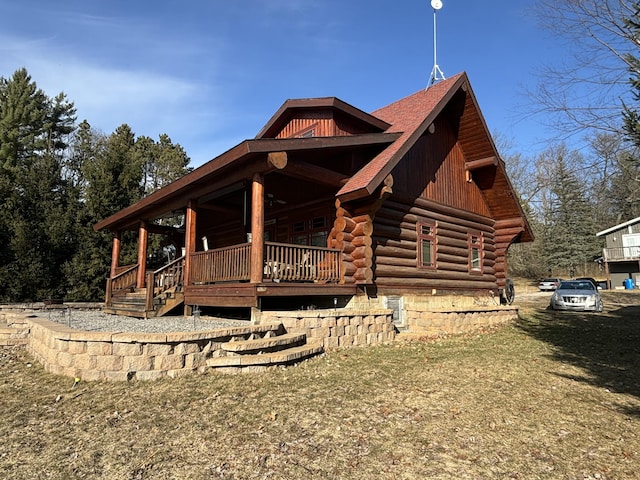 view of home's exterior with log exterior and covered porch