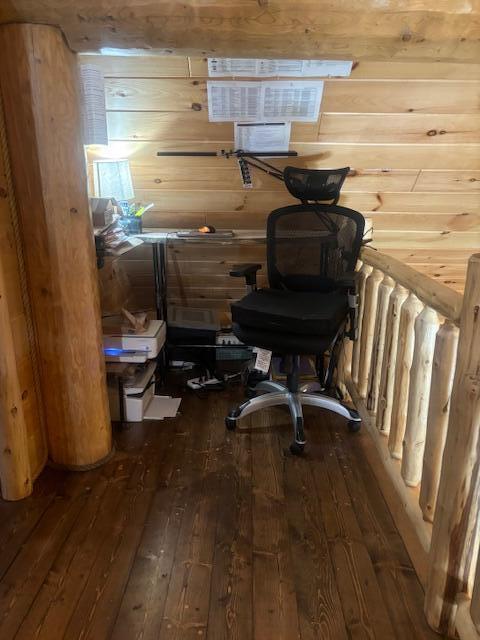 office featuring hardwood / wood-style floors and wooden walls