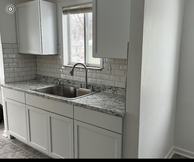 22131 Nevada Ave, Eastpointe, MI 48021 - kitchen featuring a sink, tasteful backsplash, white cabinets, and light countertops