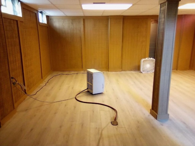 22131 Nevada Ave, Eastpointe, MI 48021 - basement with wooden walls, a paneled ceiling, and light wood-type flooring