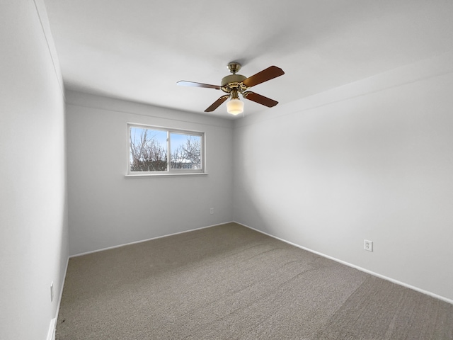 carpeted spare room featuring a ceiling fan