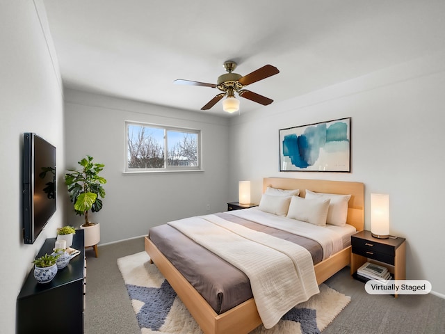 carpeted bedroom with ceiling fan and baseboards