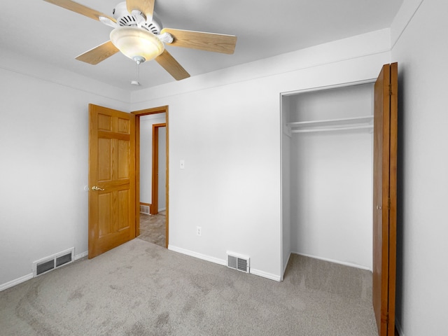 unfurnished bedroom featuring carpet flooring, a closet, visible vents, and ceiling fan
