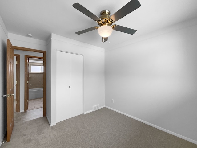 unfurnished bedroom featuring a closet, a ceiling fan, visible vents, baseboards, and carpet floors