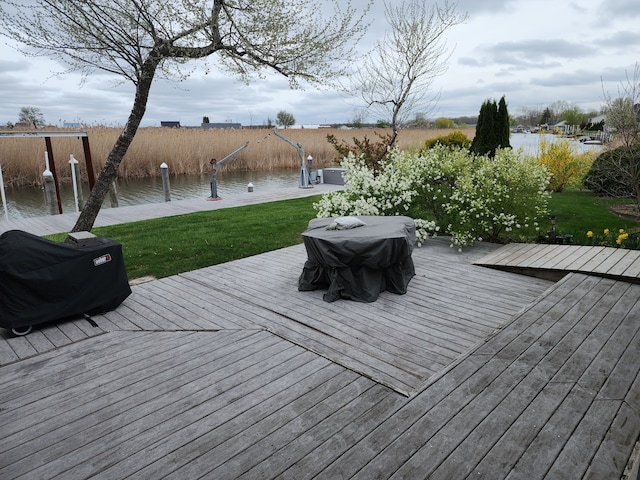 wooden deck featuring a water view and a dock