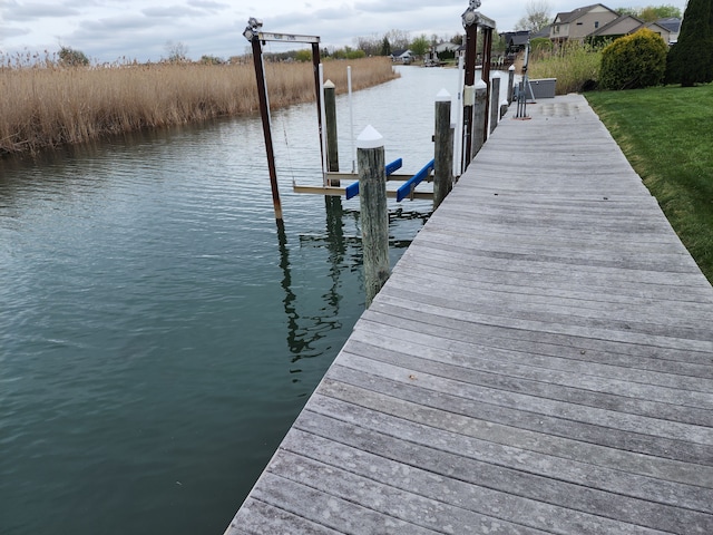 dock area featuring boat lift and a water view