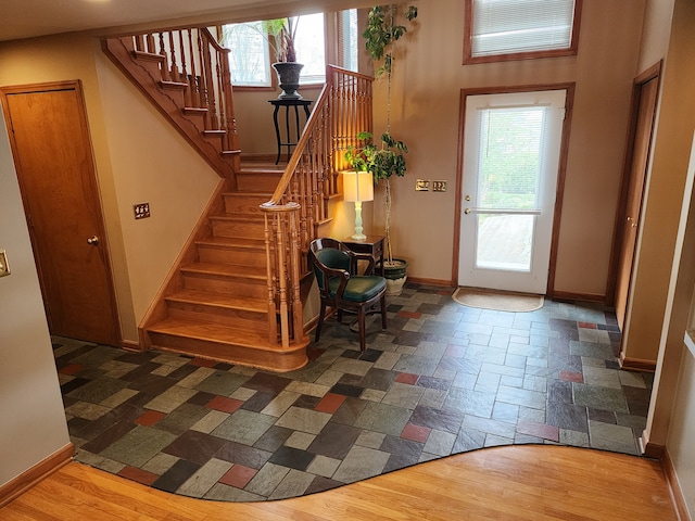 foyer featuring plenty of natural light, stairway, and baseboards