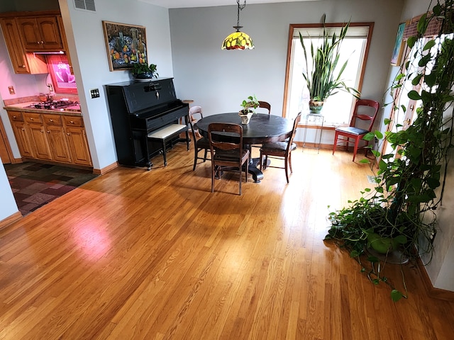 dining room with baseboards, visible vents, and wood finished floors