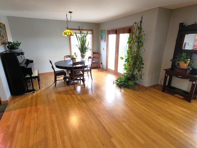 dining room featuring baseboards and light wood finished floors
