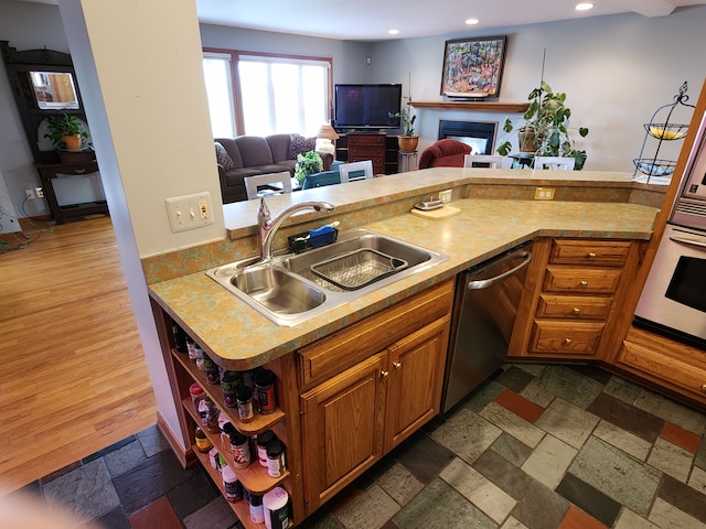 kitchen with stainless steel dishwasher, open floor plan, recessed lighting, and a sink