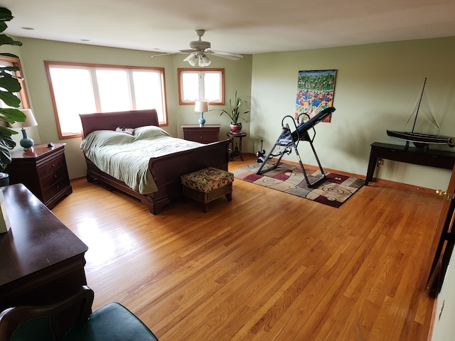 bedroom with a ceiling fan and light wood-type flooring