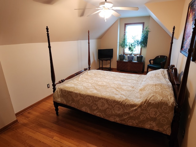 bedroom featuring vaulted ceiling, baseboards, a ceiling fan, and wood finished floors