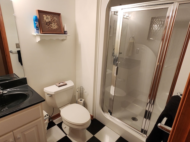 bathroom with tile patterned floors, toilet, a stall shower, and vanity