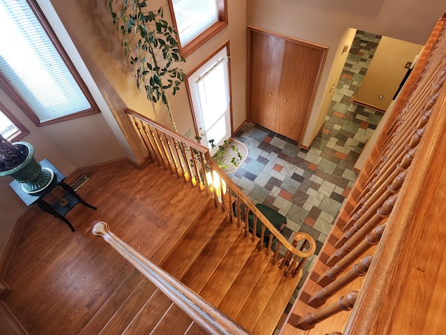 foyer featuring baseboards, a wealth of natural light, and stairway
