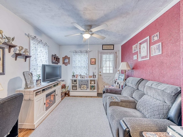 living room featuring light wood-style flooring, baseboards, a textured ceiling, and ceiling fan