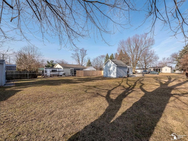 view of yard with a storage unit, an outdoor structure, and fence