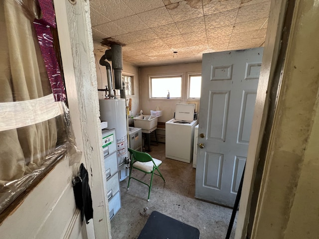 bathroom featuring a sink, independent washer and dryer, and water heater
