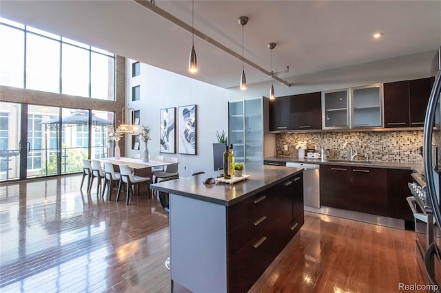 100 N Center St Unit 302, Royal Oak, MI 48067 - kitchen featuring modern cabinets, dark countertops, backsplash, stainless steel dishwasher, and a towering ceiling