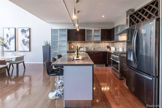 100 N Center St Unit 302, Royal Oak, MI 48067 - kitchen featuring stainless steel appliances, dark brown cabinets, a center island, a kitchen bar, and tasteful backsplash